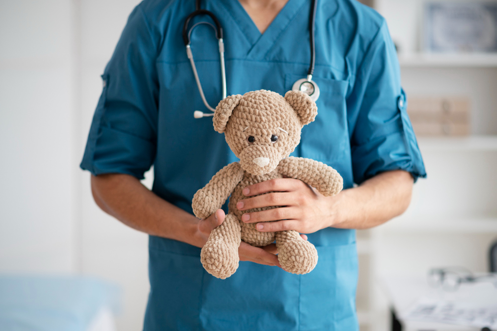 Profissional da saúde, com um estetoscópio pendurado no pescoço, segurando um urso de pelúcia. Profissional da saúde, com um estetoscópio pendurado no pescoço, segurando um urso de pelúcia.